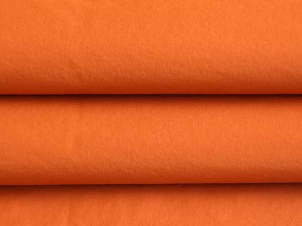 Folded bright orange cotton fabric commonly used in making plush toys and textile products.