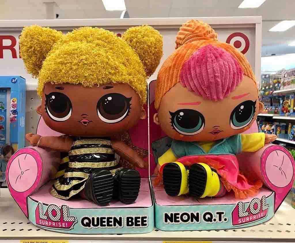 LOL Surprise Queen Bee and Neon Q.T. plush dolls with big eyes and colorful outfits on store display.
