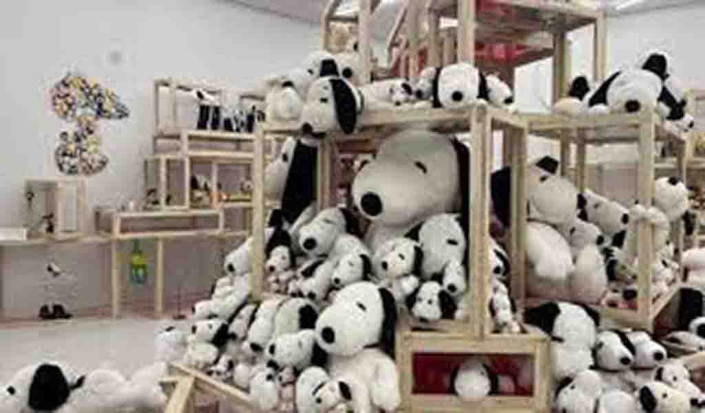 Large pile of Snoopy stuffed toys arranged on wooden shelves in a store.