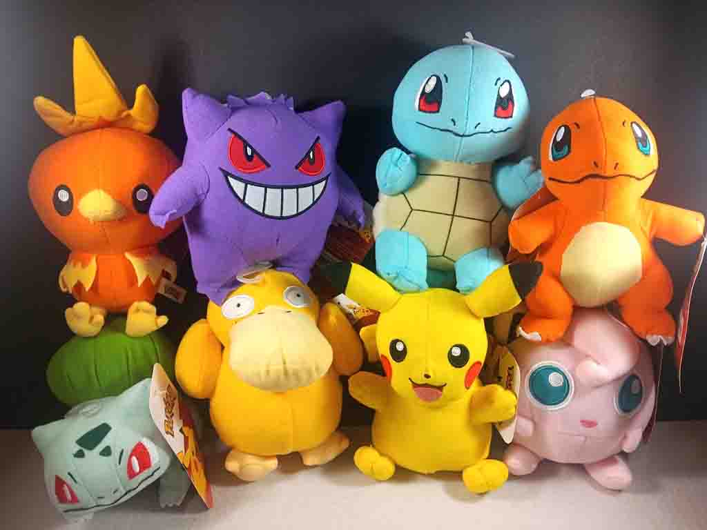 Colorful collection of Pokémon plush toys including Pikachu, Charmander, Squirtle, Bulbasaur, Jigglypuff, Psyduck, Gengar, and Torchic.