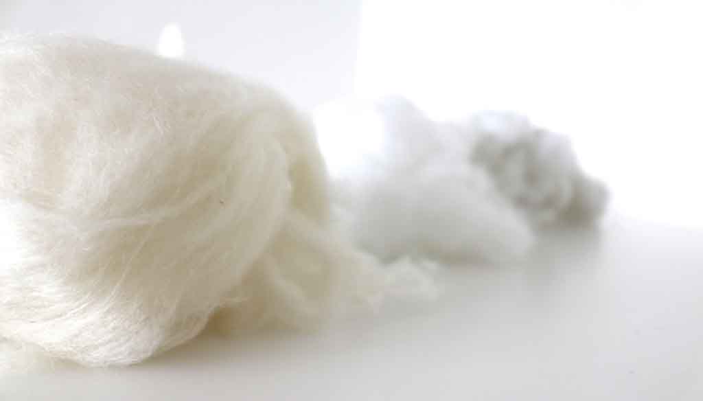 Close-up of natural and synthetic stuffing fibers for plush toys.