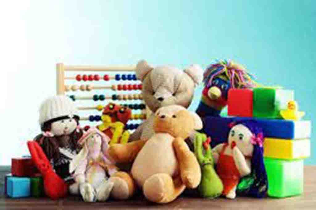 Group of colorful plush toys including teddy bears, dolls, and stuffed animals placed beside building blocks and an abacus.