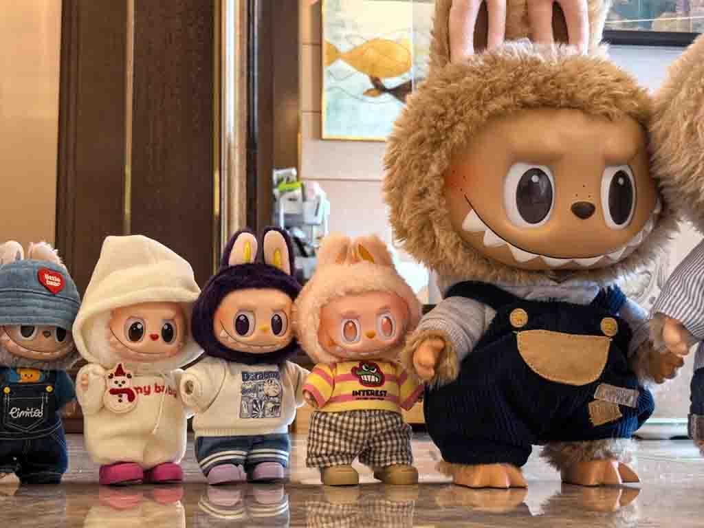 Collection of Labubu character plush dolls in colorful outfits displayed indoors.