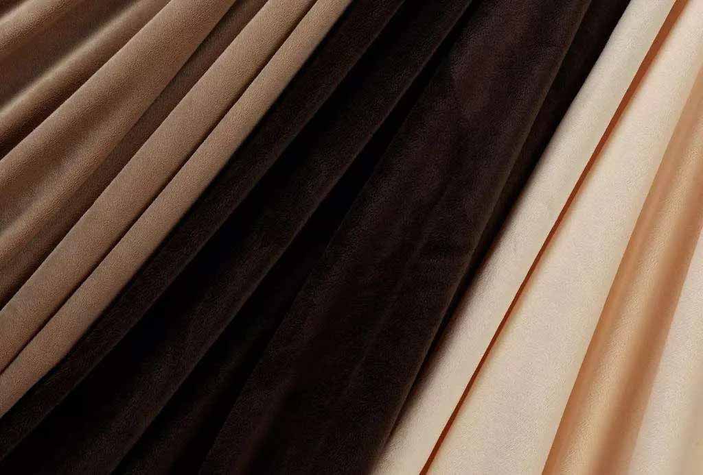 Close-up of soft velvet fabric in shades of brown, beige, and gold, often used for premium plush toys.