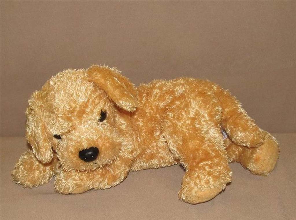 Soft golden retriever stuffed animal lying down with floppy ears and a relaxed pose on a neutral background.