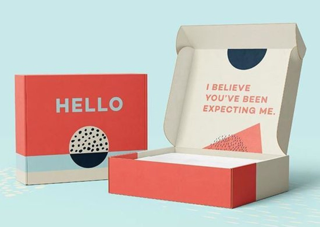 Modern custom packaging box with bold text “HELLO” on the outside and “I BELIEVE YOU’VE BEEN EXPECTING ME” printed on the inside flap.