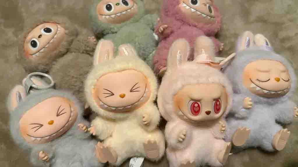 A set of pastel-colored plush dolls with expressive cartoon faces, bunny ears, and unique designs, showcasing collectible and trendy plush toys.