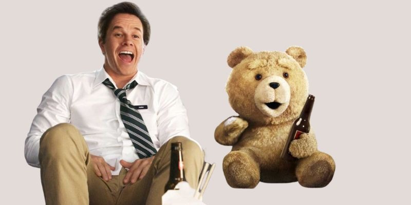 Scene from the movie Ted showing a man sitting and laughing beside a talking teddy bear holding a beer bottle.