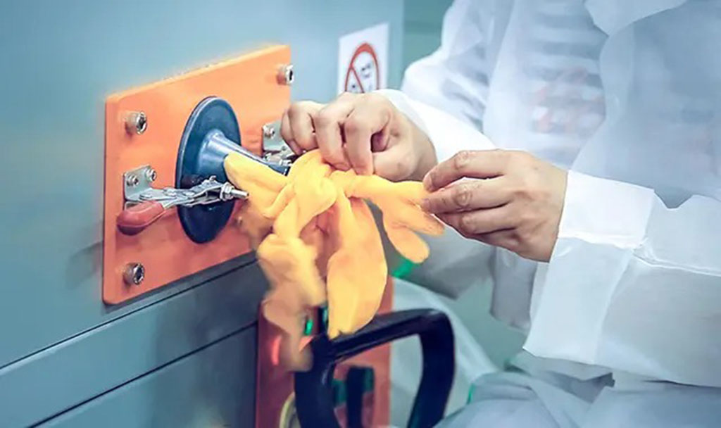 Worker using a stuffing machine to fill a plush toy with soft material during the manufacturing proce