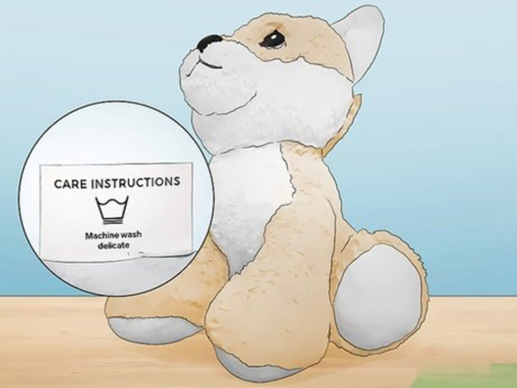 Illustration of a plush dog toy with a close-up of its care label showing "Machine wash delicate."