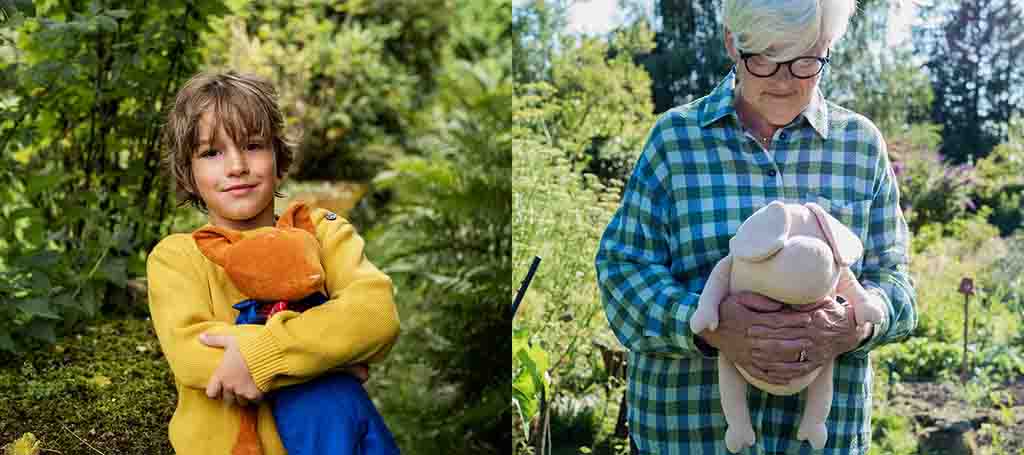 Child hugging an orange plush toy and older person holding a pale stuffed animal outdoors in a garden.