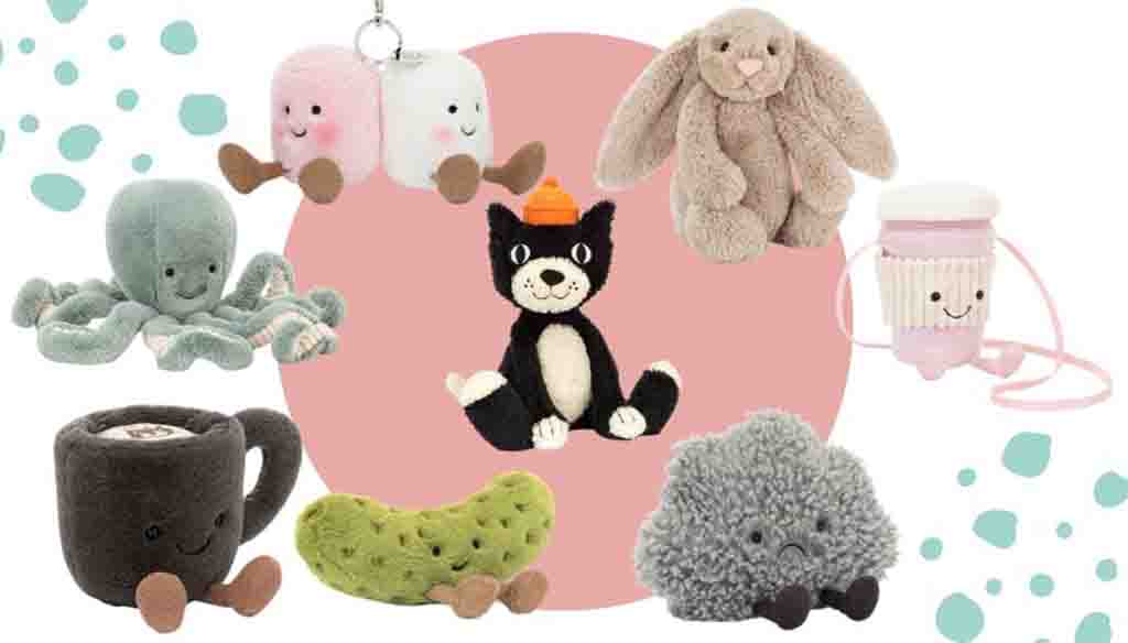 A collection of Jellycat plush toys including an octopus, bunny, cat, coffee cup, pickle, marshmallows, cupcake, and fluffy cloud arranged on a pink circle background.