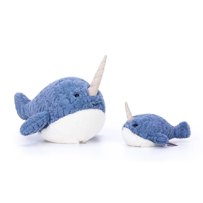 Two soft blue narwhal plush toys, one large and one small, with white bellies and striped spiral tusks, positioned facing each other on a white background.