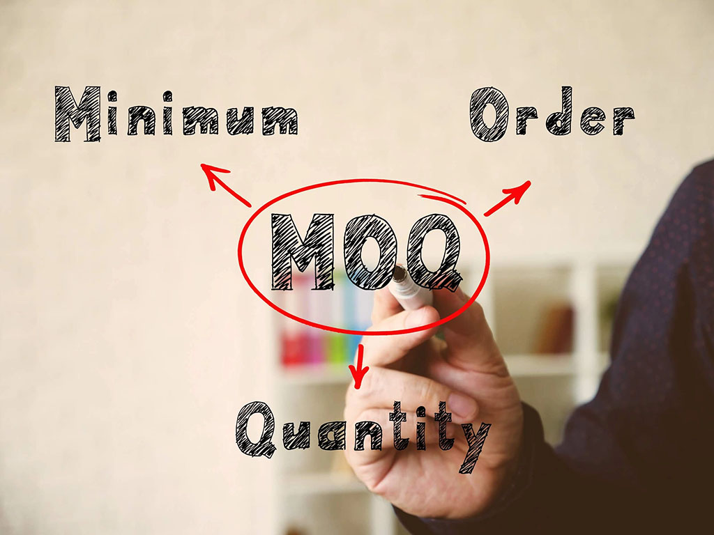 Business person circling the abbreviation “MOQ” on a transparent board with arrows pointing to the words “Minimum,” “Order,” and “Quantity,” illustrating the concept of minimum order quantity in production.