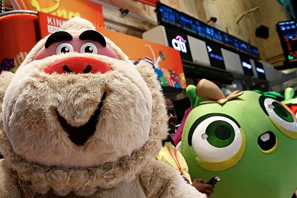 Large plush character mascots with smiling faces on display at an event, representing colorful animated figures in a promotional setting.