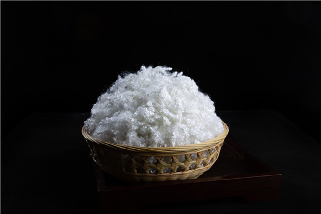 A basket filled with fluffy white hollow conjugate polyester fiber used as premium filling material for plush toys and cushions.