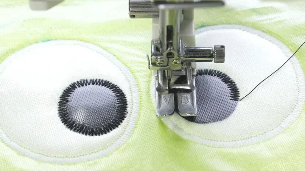 Close-up view of a sewing machine embroidering cartoon eyes onto soft plush fabric, showcasing precision stitching for plush toy detailing.