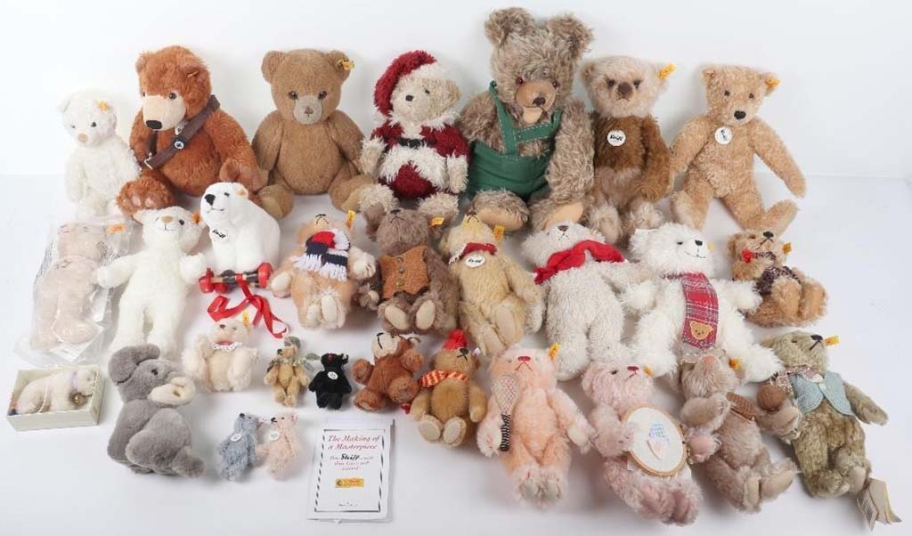  Large assortment of classic and modern teddy bears in various sizes, colors, and outfits displayed on a white background.