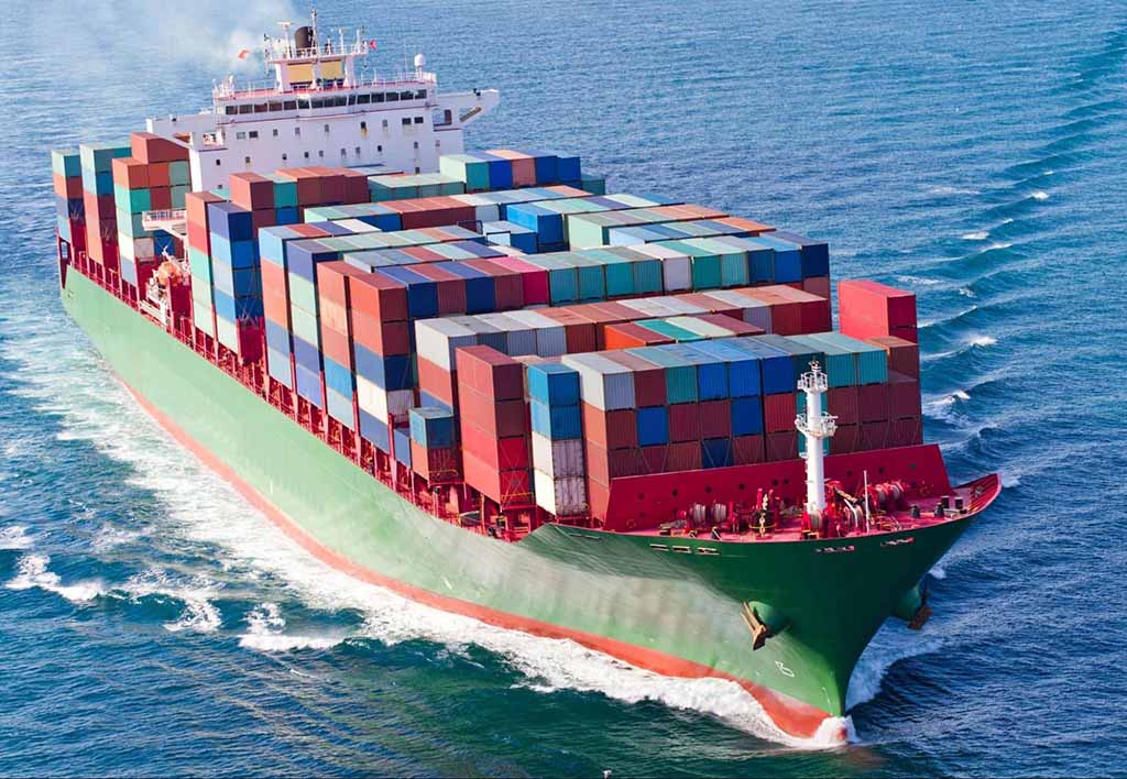 Large container ship carrying multicolored cargo containers sailing through the ocean, representing global shipping and international trade logistics.
