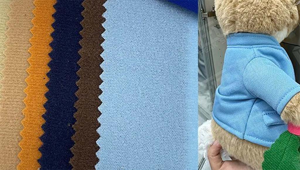 Assorted velour fabric swatches in multiple colors beside a plush toy wearing a blue velour jacket.
