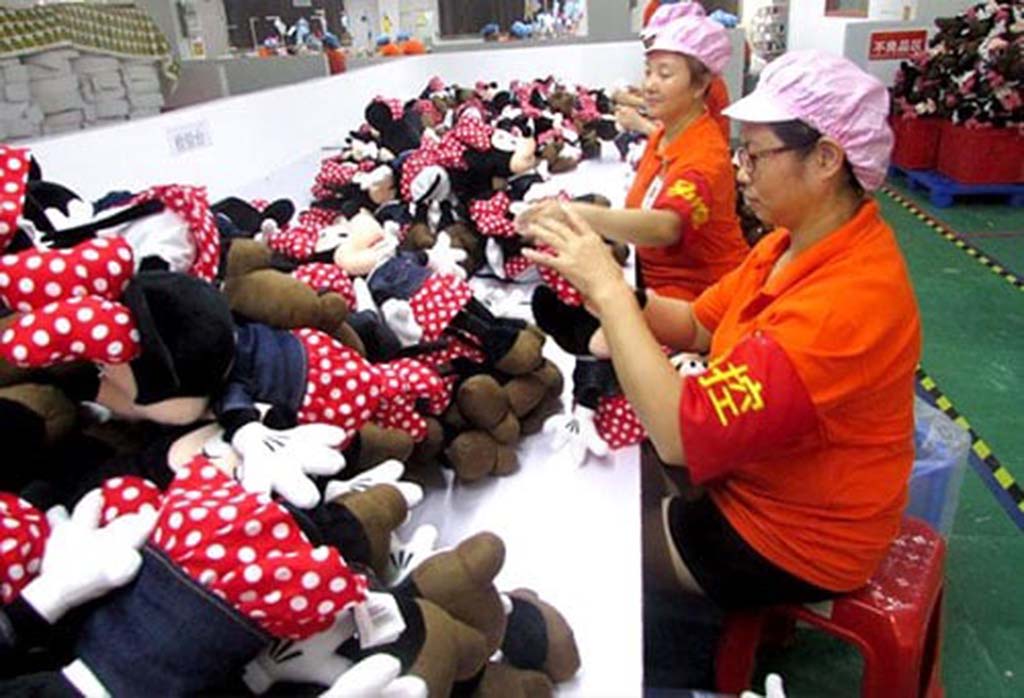 Factory workers inspecting and sorting Minnie Mouse plush toys on a production line in China.