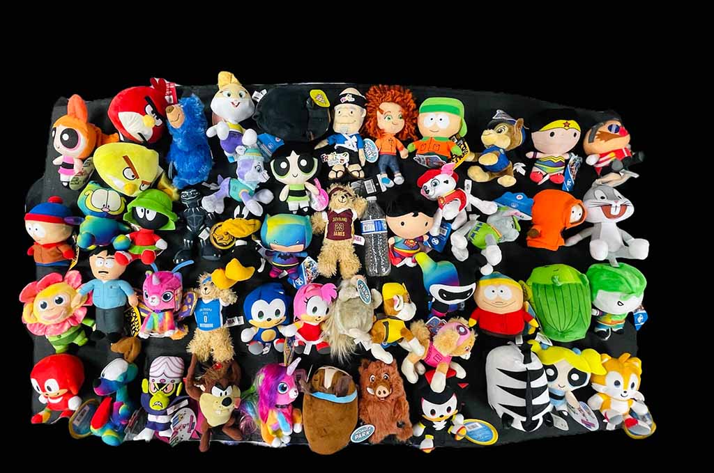 A colorful assortment of cartoon and game character plush toys arranged on a black background, featuring various popular animated figures.