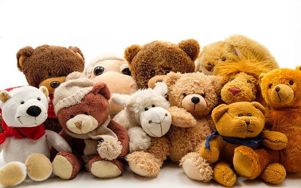 Collection of plush toys including teddy bears, lions, and lambs in various shades of brown and white arranged together against a white background.
