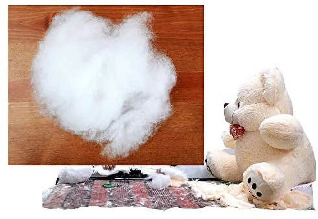 White polyester fiberfill used as stuffing for plush toys, shown beside a white teddy bear being repaired on a work surface.