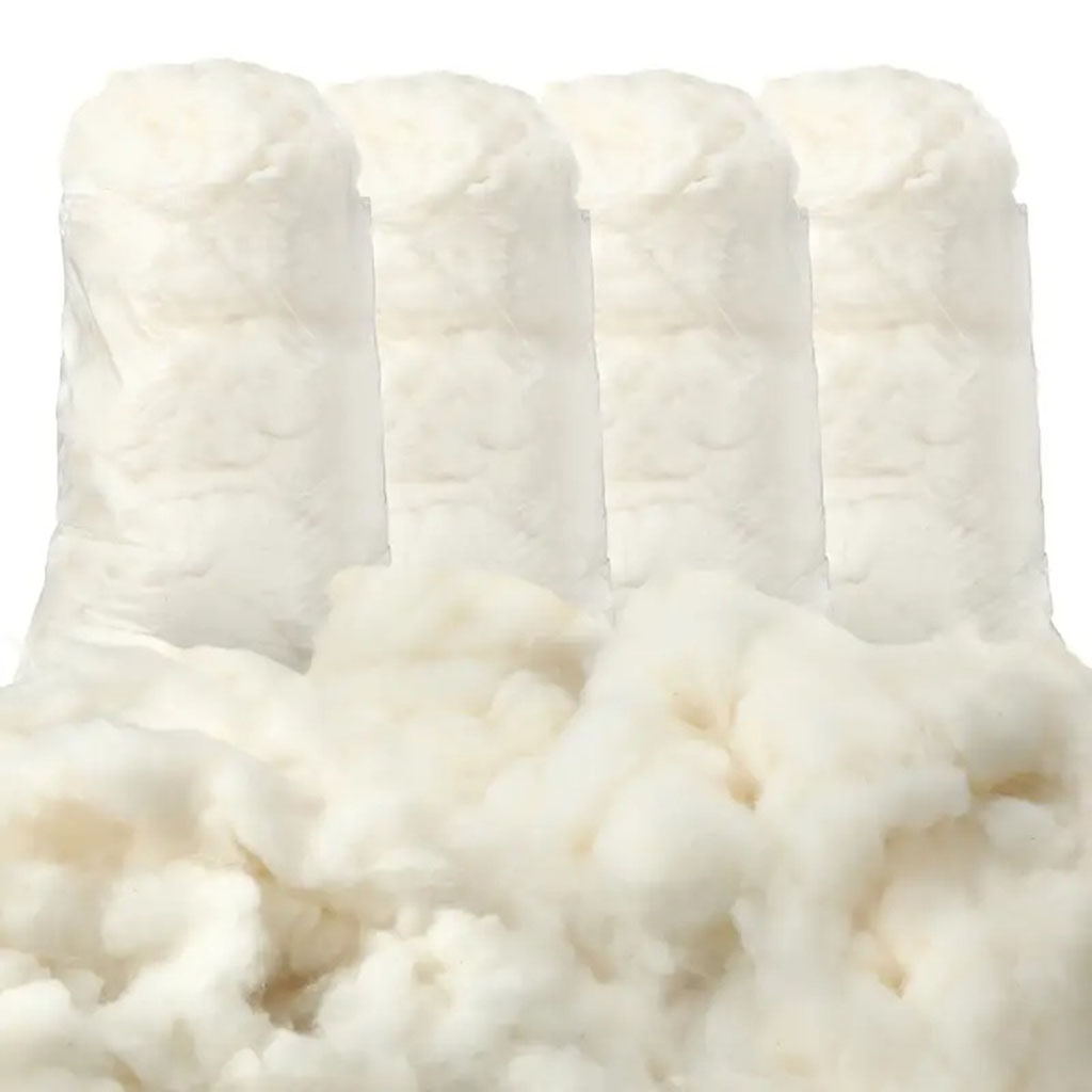Close-up of soft white cotton fiber rolls and loose cotton used as natural stuffing material for plush toys.