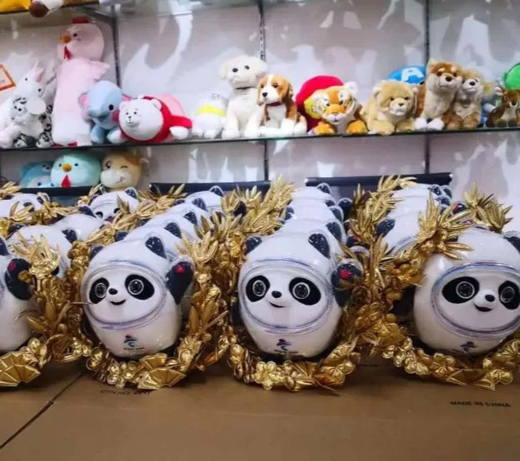 Rows of panda plush toys with golden wreath decorations displayed in a factory showroom, representing mass production of licensed character plushes.