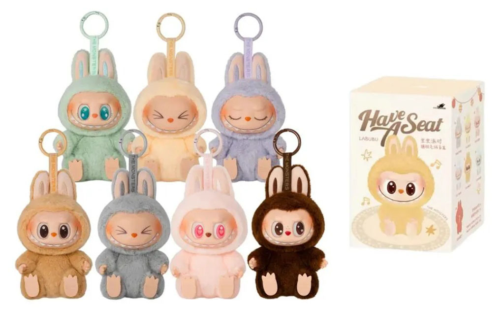 Set of seven Labubu plush keychains in assorted pastel and earthy colors with bunny ears, displayed beside the original “Have A Seat” packaging box.