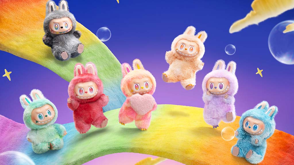 Colorful Labubu plush dolls in various pastel and bright costumes posed on a rainbow background with stars and bubbles.