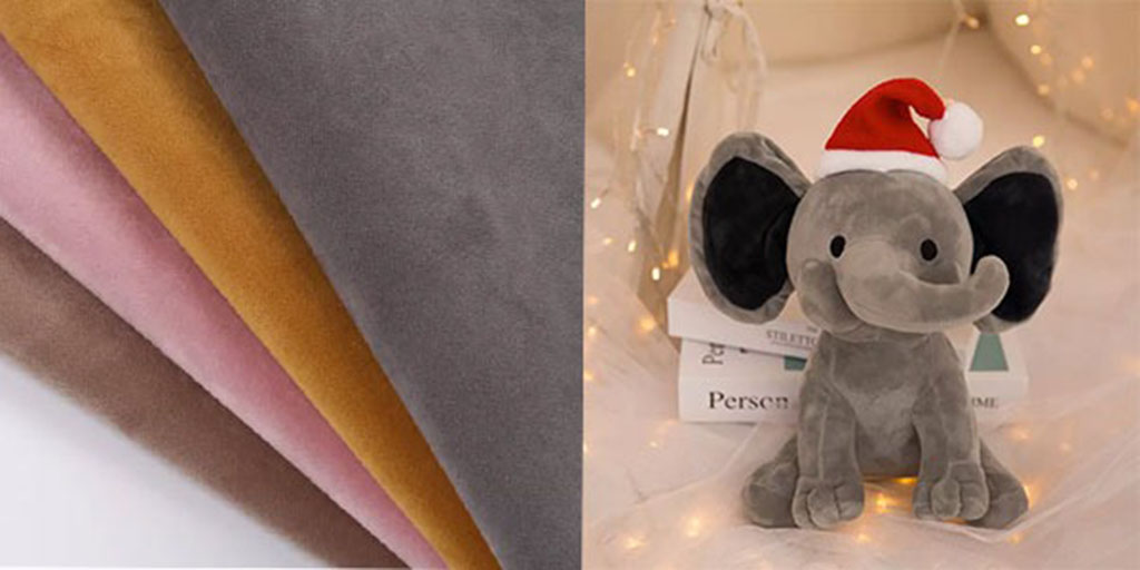 Soft short plush fabrics in multiple colors next to a gray elephant plush toy wearing a Santa hat, showing how the material is used in toy production.