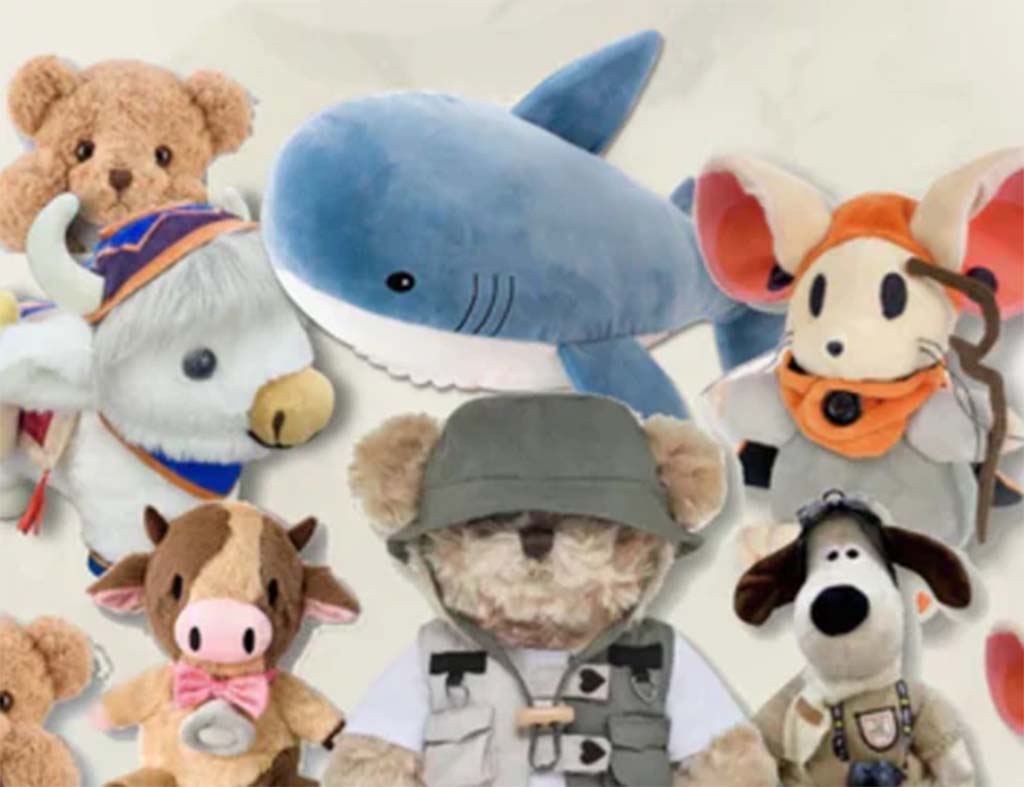 A collection of custom-designed stuffed animals including a shark, cow, mouse, teddy bear, and other uniquely styled plush characters arranged together.