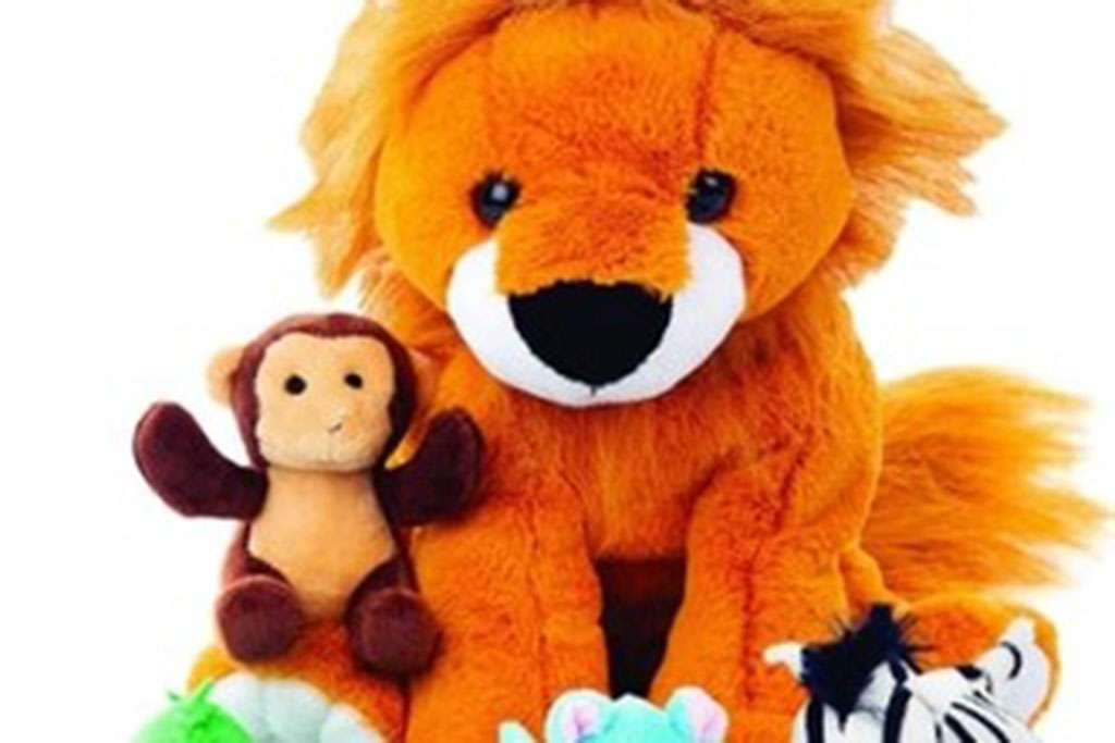 A large orange plush lion surrounded by smaller stuffed animals including a monkey, zebra, and other colorful plush toys.