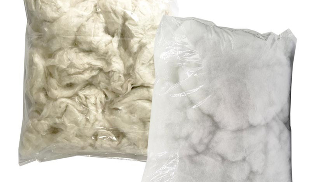  Two transparent bags filled with natural kapok fiber and cotton stuffing, used for eco-friendly plush toy filling.