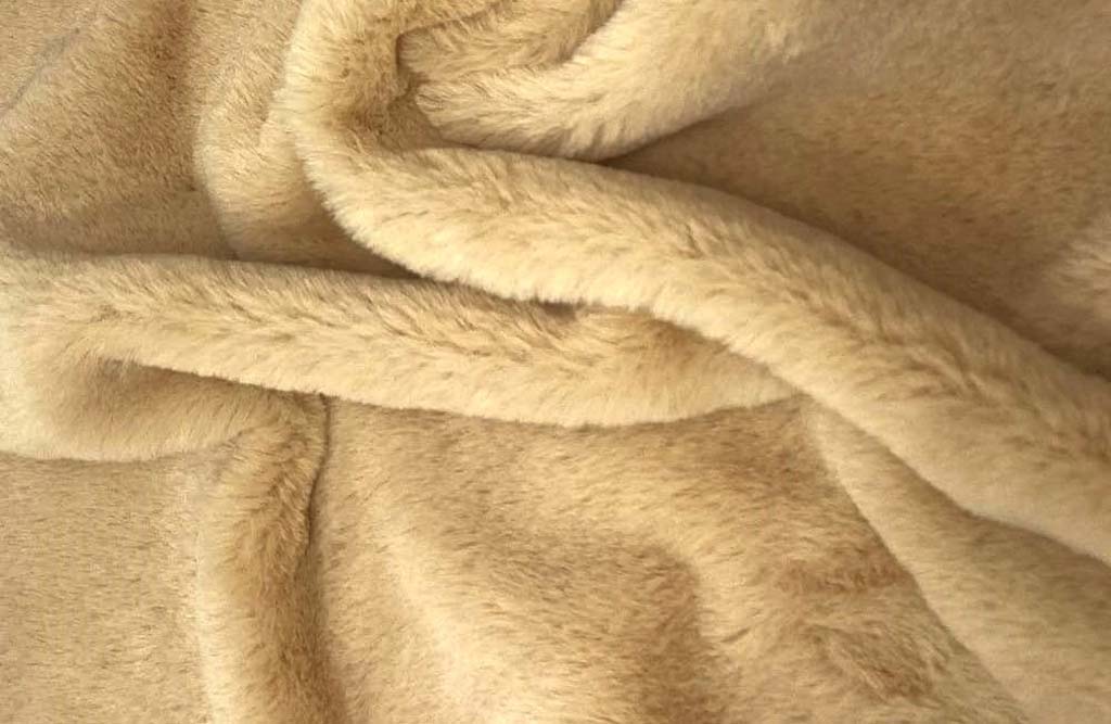 Soft beige plush fur fabric shown in close-up with a smooth, fluffy surface and gentle folds, commonly used in manufacturing teddy bears and high-quality stuffed animals.