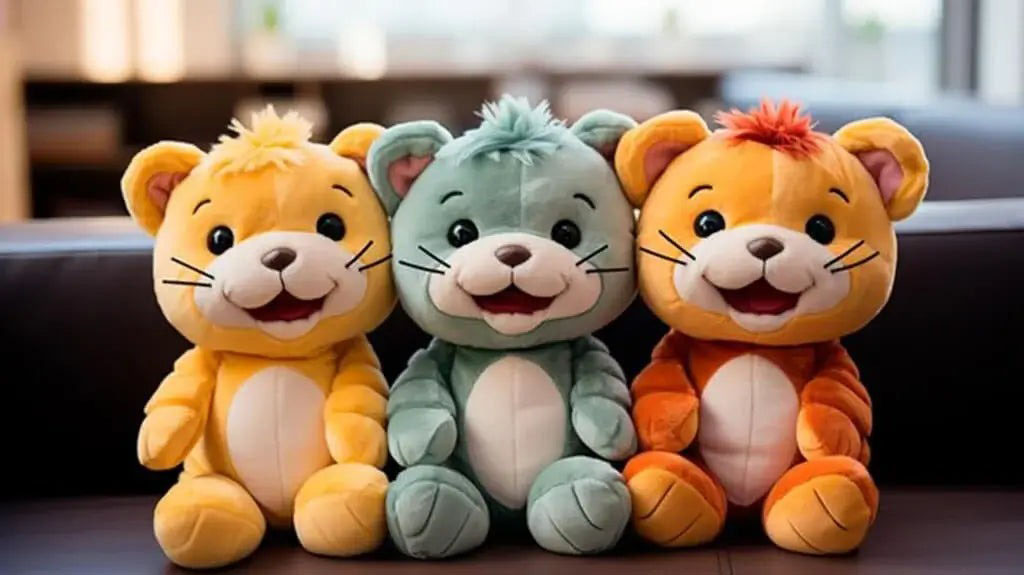 A group of three colorful plush tiger toys—yellow, teal, and orange—sitting side-by-side on a dark couch, each with smiling faces and embroidered details.