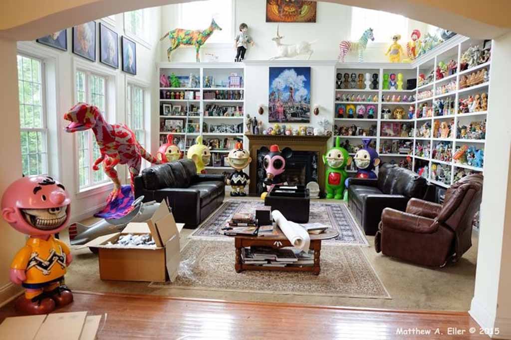 Room filled with large designer toys and shelves packed with colorful collectible figurines.