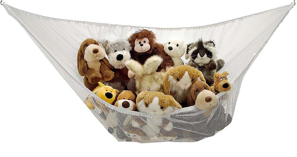 White mesh stuffed animal hammock mounted in a corner and filled with various plush toys including dogs, monkeys, bears, and other animals.
