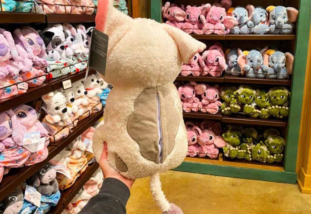 Rows of blue and red Mickey Mouse plush toys neatly arranged on shelves inside a Disney retail store.