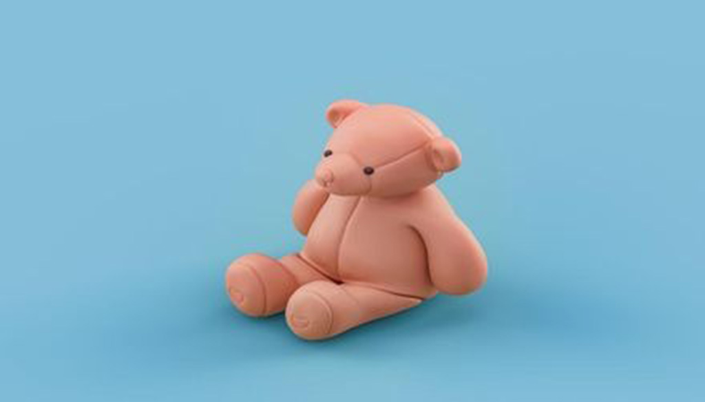 A simple peach-colored teddy bear figurine sitting upright on a light blue background.
