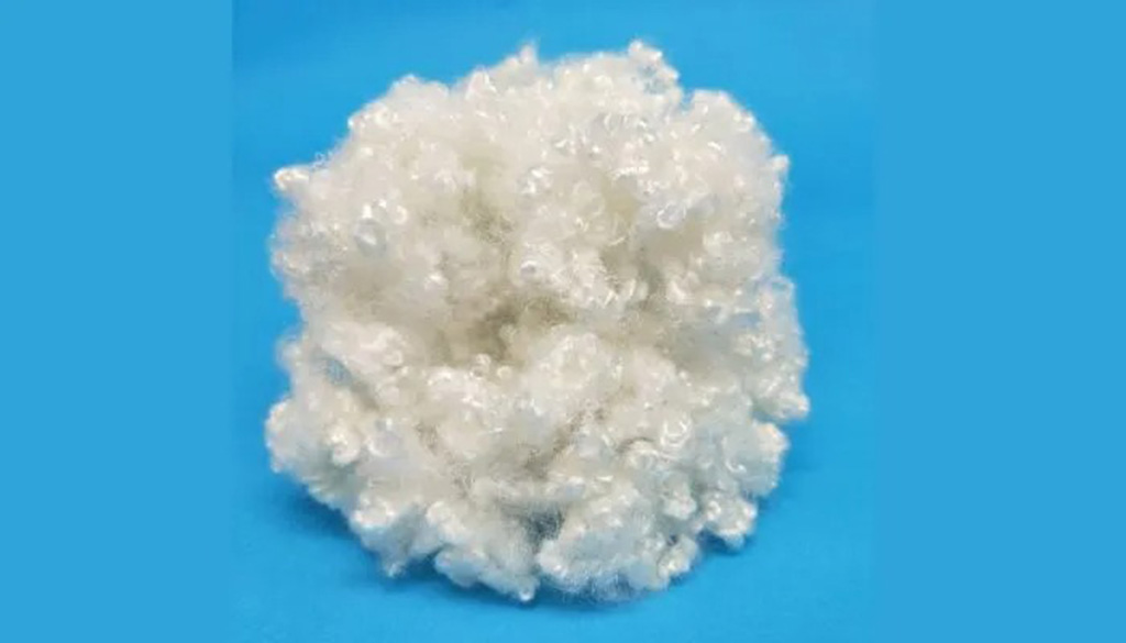  A cluster of curly siliconized polyester fiberfill on a blue background, commonly used as plush toy stuffing for extra softness and bounce.