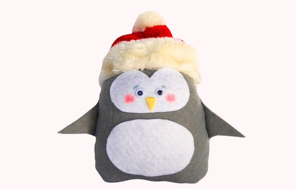 Handmade grey and white penguin plush wearing a red Santa hat, crafted from felt fabric with hand-sewn details.