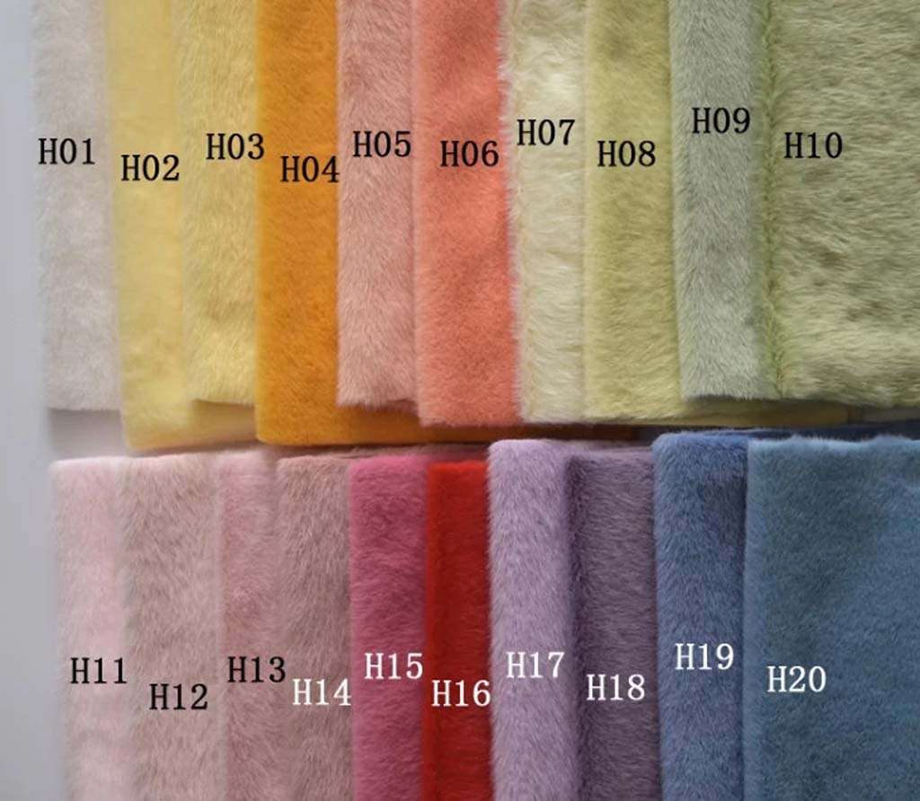 A color chart of long-pile plush fabric displaying 20 swatches labeled H01 to H20, arranged in gradients from white, yellow, peach, and green to pink, red, purple, and blue—commonly used for custom plush toys and stuffed animal manufacturing.
