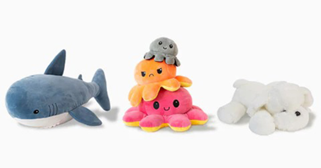 Three soft plush toys including a blue shark, a stack of colorful octopuses, and a white puppy displayed on a white background.