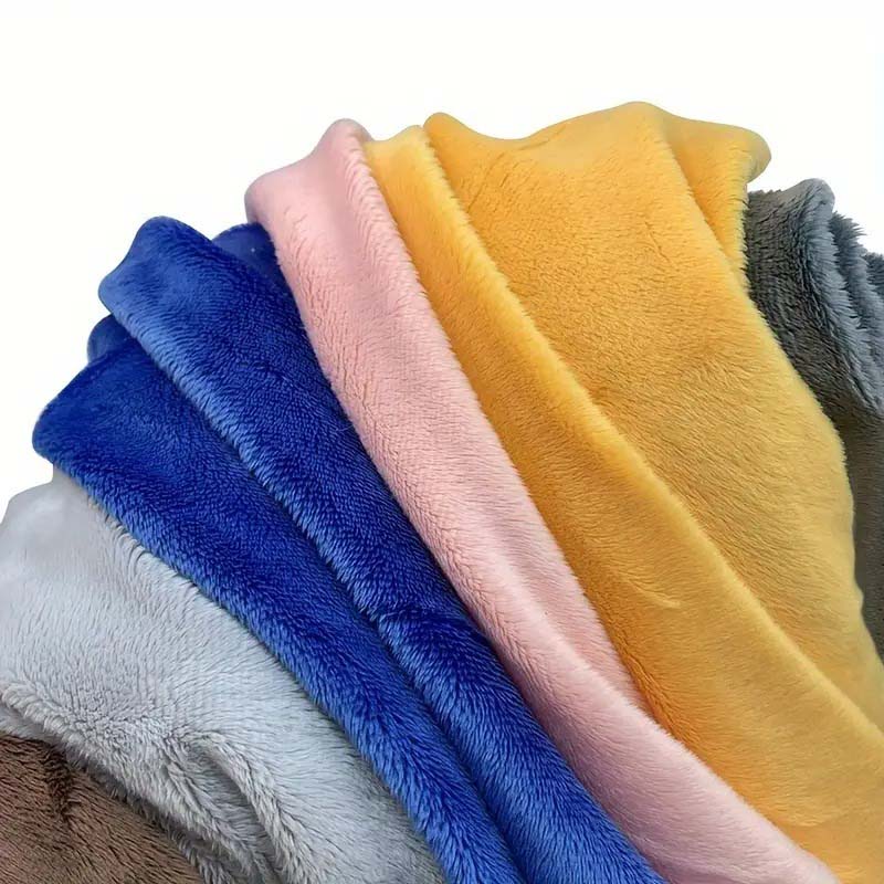 Soft plush fabric sheets in multiple colors—yellow, pink, blue, gray, and beige—stacked together to show texture and material options for plush toys.