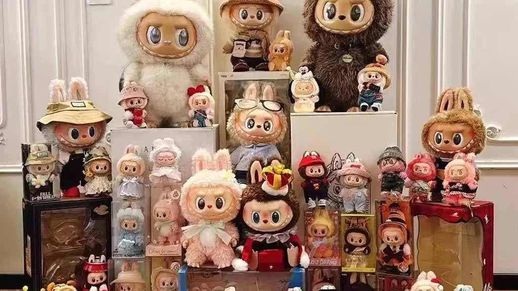 A large display of Labubu plush and vinyl figures arranged on stands, showcasing various designs, outfits, and collectible packaging in a decorated indoor setting.