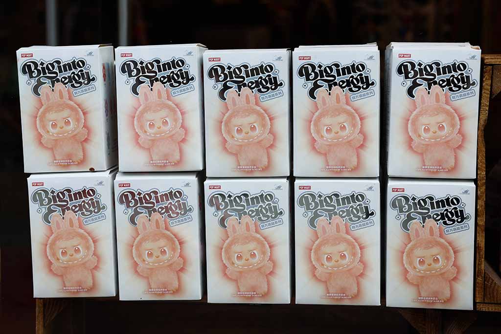 Multiple Pop Mart “Biginto Energy” blind box packages arranged in two rows, each showing a cute bunny-costumed character on the front, displayed neatly on a shelf.