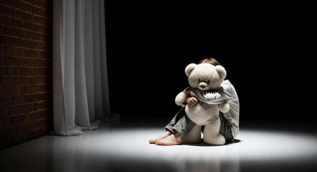 A child sitting alone on the floor hugging a teddy bear under dramatic lighting, symbolizing loneliness, comfort, and emotional support from plush toys.